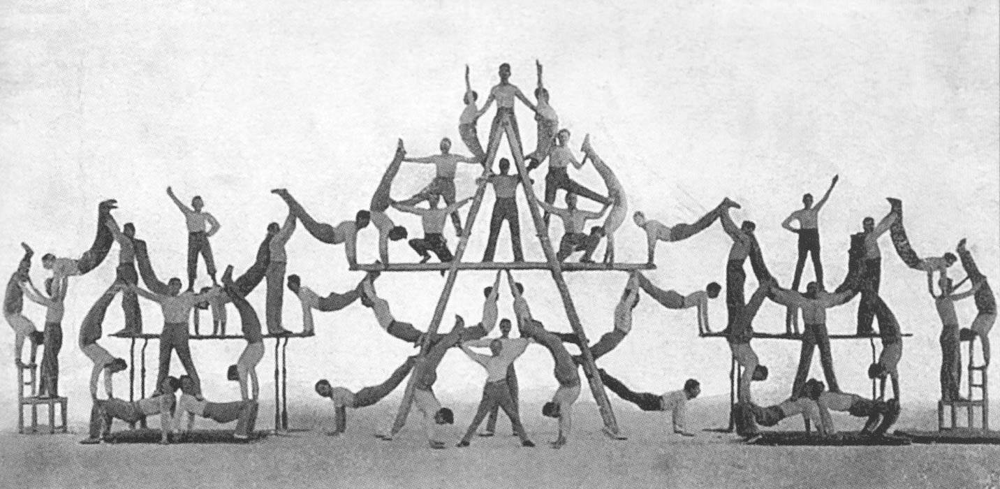 altes Foto: viele Menschen bilden akrobatisch eine wellenförmige Wand.